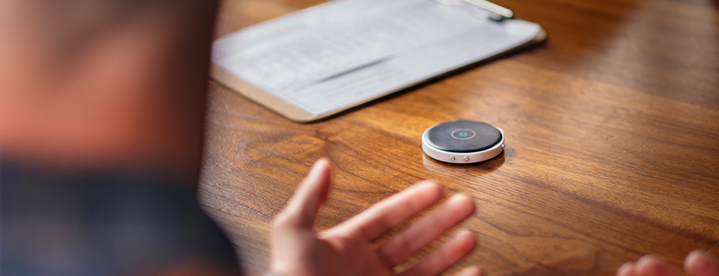 Image of hearing aid wearer using a table microphone on a table